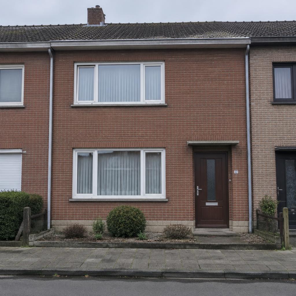 Voorgevel van een rijwoning met oude witte ramen